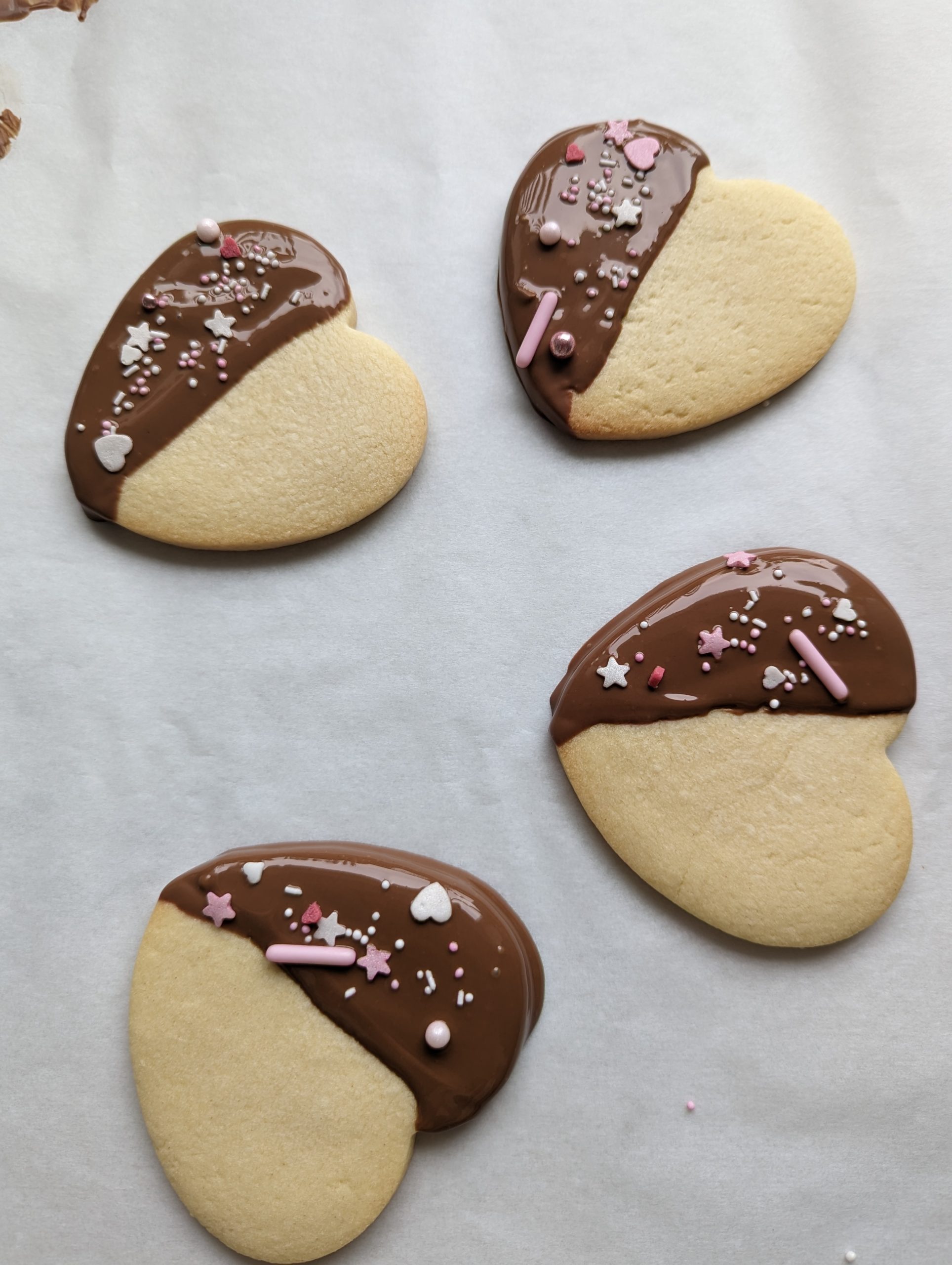 Chocolate-dipped heart sugar cookies topped with sprinkles